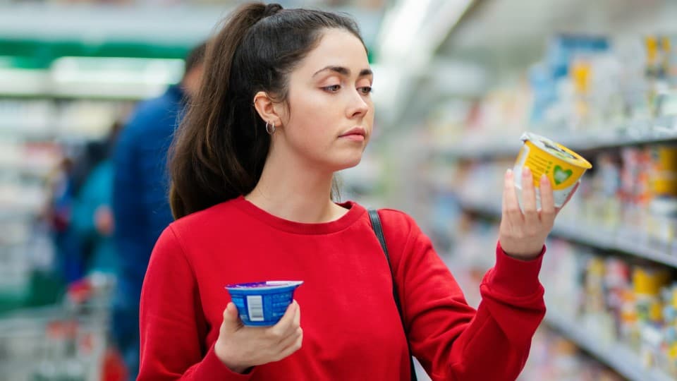 A woman looks at dessert options in a supermarket